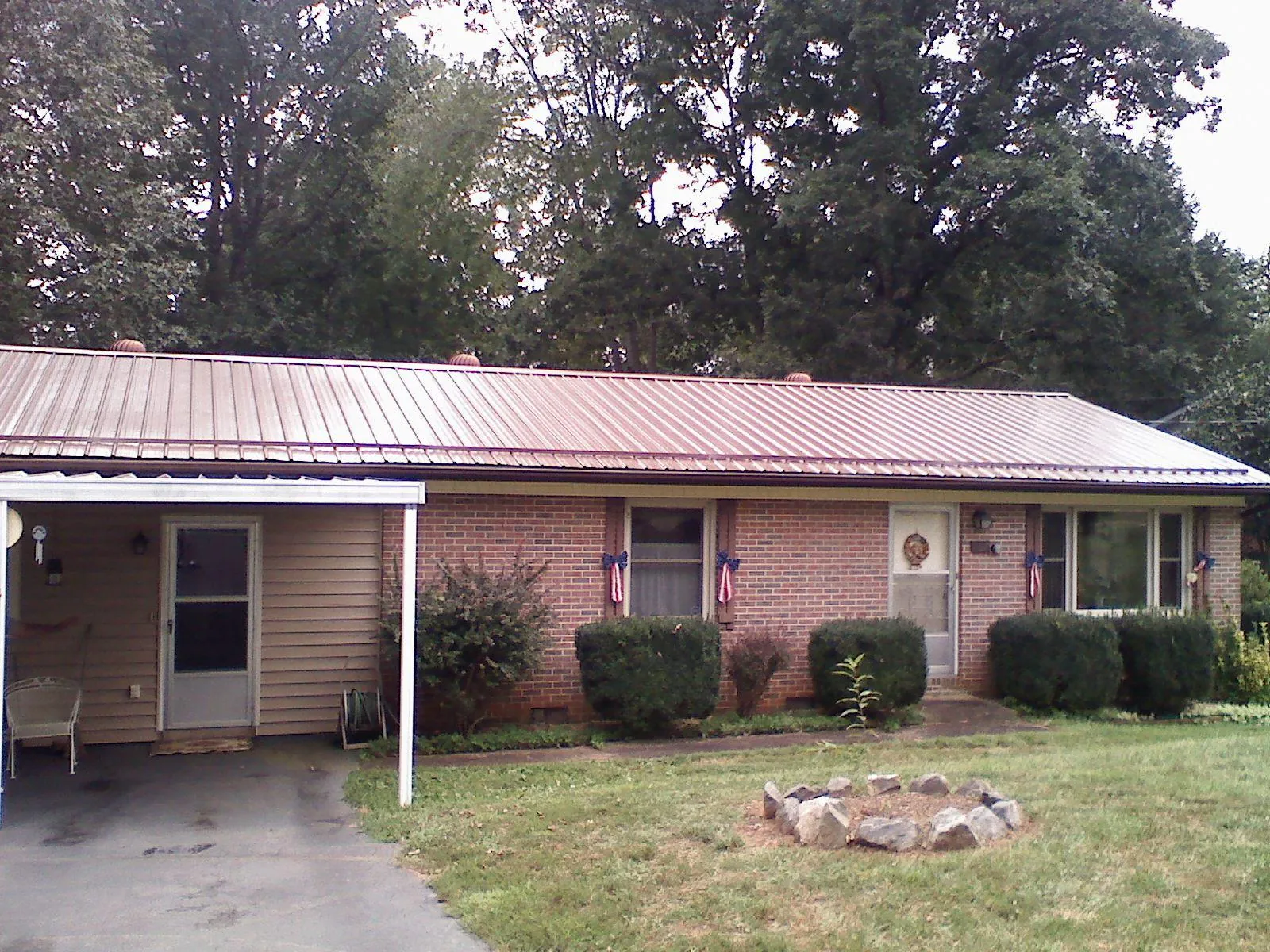 Bronze metal roof and carport on a brick ranch home — Roof Repair work by our crew in Cedar
